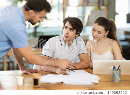 Girl and two men office staff talk and discuss working issues, discuss document papers Girl and two men office staff talk and discuss working issues, discuss document papers 140092212