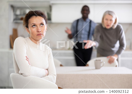 Woman not talking after disagreement with husband and mother standing behind Woman not talking after disagreement with husband and mother standing behind 140092312