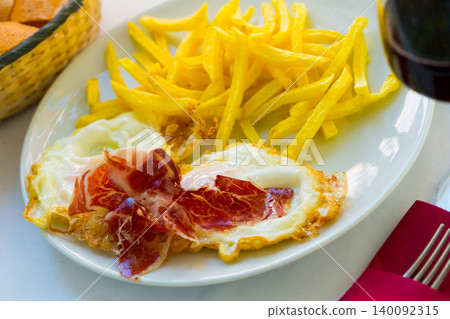 Fried eggs with ham, potatoes and wine Fried eggs with ham, potatoes and wine 140092315