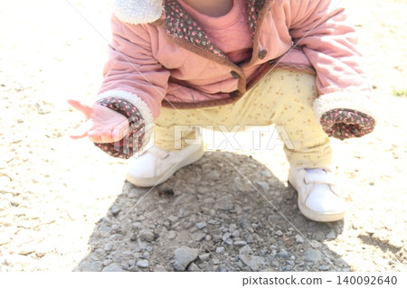 Images of toddlers playing in the sand and children picking up stones. Images of toddlers playing in the sand and children picking up stones. 140092640