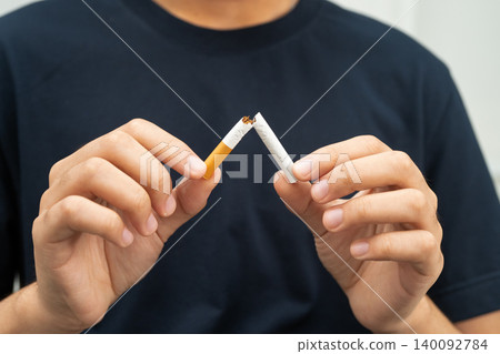 Quit smoking, Asian teenage man breaking destroy cigarette in hand. Quit smoking, Asian teenage man breaking destroy cigarette in hand. 140092784