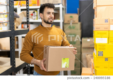 Young man placing package in grocery warehouse Young man placing package in grocery warehouse 140093186