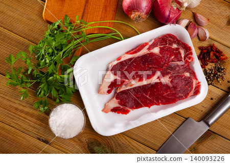 Preparation of raw beef fillet with parsley and garlic on wooden board Preparation of raw beef fillet with parsley and garlic on wooden board 140093226