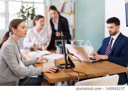 Pregnant young woman works at computer in office 140093237