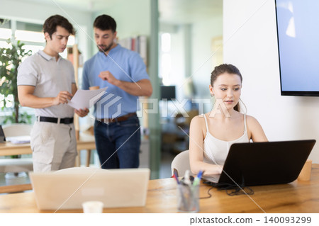 Girl staff working at laptop computer in office room space Girl staff working at laptop computer in office room space 140093299
