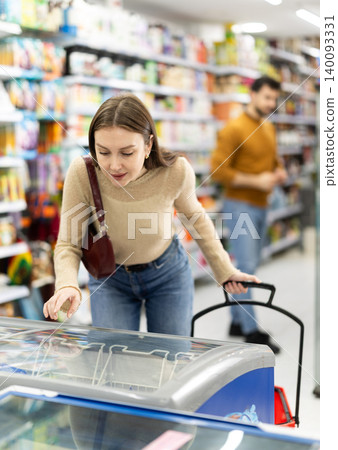 Young woman choosing frozen food in grocery store 140093331