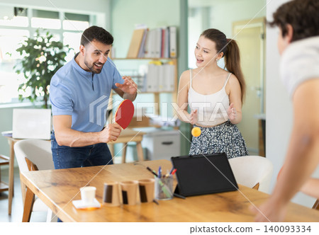 Young people playing table tennis in office at work Young people playing table tennis in office at work 140093334