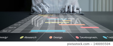 Hands on Table Using Gantt Chart for Project Management Planning with Colorful Tasks Representing Different Phases of Workflow in Modern Office Cyphers. Hands on Table Using Gantt Chart for Project Management Planning with Colorful Tasks Representing Different Phases of Workflow in Modern Office Cyphers. 140093504