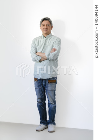 一位六十多歲的男子雙手交叉抱在胸前,面帶微笑,直視鏡頭。 一位六十多歲的男子雙手交叉抱在胸前,面帶微笑,直視鏡頭。 140094144