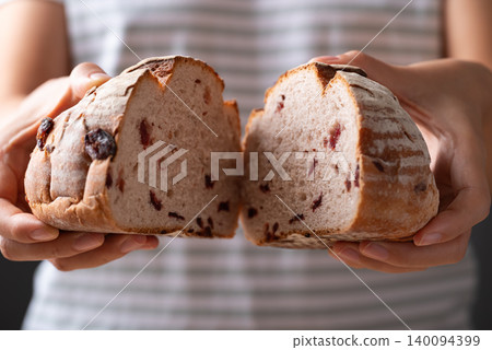 Cranberry sourdough bread holding by woman hand, Homemade bakery and healthy eating Cranberry sourdough bread holding by woman hand, Homemade bakery and healthy eating 140094399
