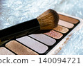 Close up view of eyeshadow palette featuring neutral nude and shimmering glitter shades representing essential cosmetics for daily beauty routines 140094721
