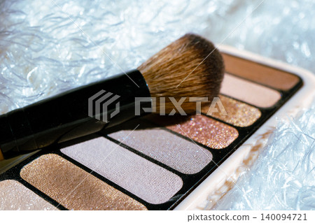 Close up view of eyeshadow palette featuring neutral nude and shimmering glitter shades representing essential cosmetics for daily beauty routines Close up view of eyeshadow palette featuring neutral nude and shimmering glitter shades representing essential cosmetics for daily beauty routines 140094721