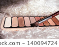 Eyeshadow palette with multiple shimmer and matte shades, featuring a range of warm and neutral tones for beauty looks 140094724