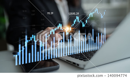 Business professional analyzing financial data on laptop with digital charts showing market trends and stock performance in an office setting Scalp 140094774