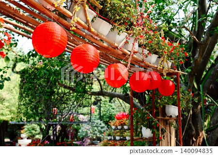 Row of red round paper lanterns hanging on a bamboo frame with flower pots at Linh Ung Pagoda on Son Tra Peninsula in Da Nang Vietnam Row of red round paper lanterns hanging on a bamboo frame with flower pots at Linh Ung Pagoda on Son Tra Peninsula in Da Nang Vietnam 140094835
