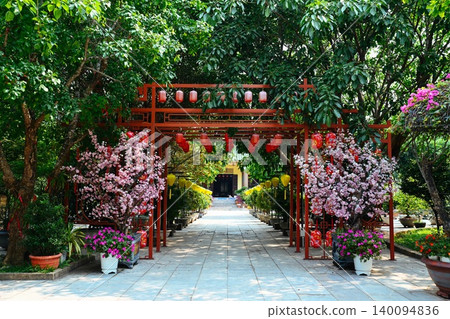 Decorative red metal archway alley with hanging lanterns and artificial pink blossom trees at Linh Ung Pagoda on Son Tra Peninsula in Da Nang Vietnam Decorative red metal archway alley with hanging lanterns and artificial pink blossom trees at Linh Ung Pagoda on Son Tra Peninsula in Da Nang Vietnam 140094836