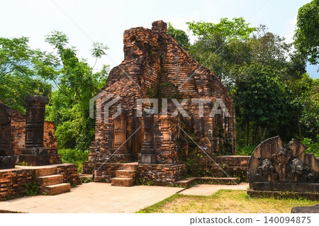 Ancient ruined red brick Hindu temple complex with stone carvings at My Son Sanctuary historical archeological site in Vietnam 140094875