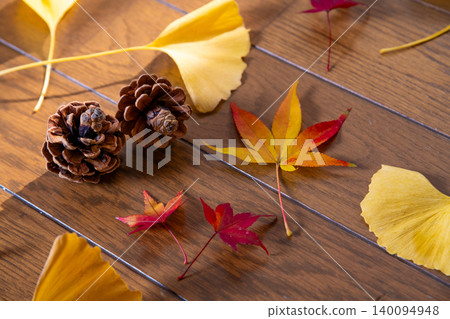 Scattered red maple leaves, ginkgo leaves, and pine cones – an image of autumn. Scattered red maple leaves, ginkgo leaves, and pine cones – an image of autumn. 140094948