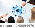 Group of Diverse Professionals Collaborating on Global Digital Network Strategy with Graphics on Table Displaying World Map and Data Connections Trope 140094970