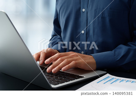 Business person using laptop at office desk. Close up of hands and keyboard. Business person using laptop at office desk. Close up of hands and keyboard. 140095381