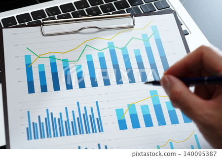 一份包含圖表、統計關鍵績效指標 (KPI) 數據和財務結果的商業分析報告。請在辦公桌前查看該計劃。 一份包含圖表、統計關鍵績效指標 (KPI) 數據和財務結果的商業分析報告。請在辦公桌前查看該計劃。 140095387