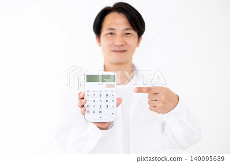 一位穿著休閒的中年男子指著一台白色計算器。 一位穿著休閒的中年男子指著一台白色計算器。 140095689