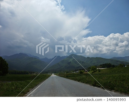 A road stretching straight towards the mountains 140095993