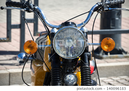 Close-Up Front View Of Vintage Motorcycle Headlight And Turn Signals Parked On Urban Street Close-Up Front View Of Vintage Motorcycle Headlight And Turn Signals Parked On Urban Street 140096183