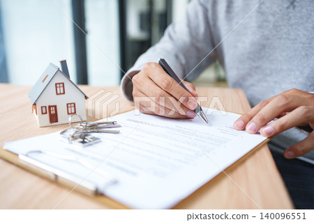 Real Estate Contract Signing For Property Purchase Mortgage Documentation And Ownership Transfer. Real Estate Contract Signing For Property Purchase Mortgage Documentation And Ownership Transfer. 140096551