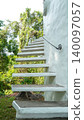 Minimalist white concrete cantilever staircase on a curved white wall 140097057