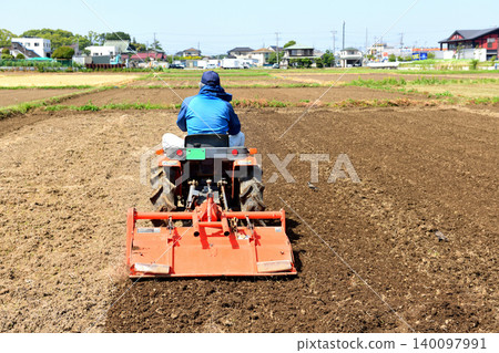A man prepares rice planting with a tractor. A man prepares rice planting with a tractor. 140097991