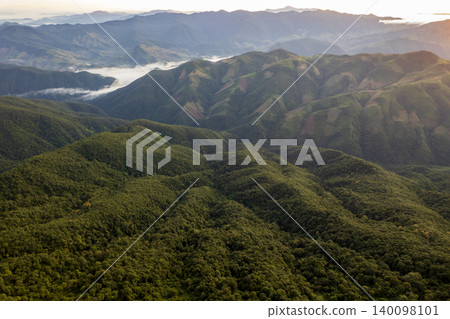 Landscape of Morning Mist with Mountain Layer. mountain ridge and clouds in rural jungle bush forest Landscape of Morning Mist with Mountain Layer. mountain ridge and clouds in rural jungle bush forest 140098101