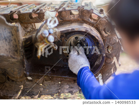 A service technician repairs a damaged hydraulic pump. Professional power hydraulics workshop. Hydraulic motor folding. Disassembly hydraulic piston pump, repair maintenance heavy machinery 140098533