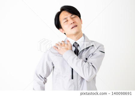 一位身穿灰色工作服的中年商人,肩膀僵硬,背景為白色。 一位身穿灰色工作服的中年商人,肩膀僵硬,背景為白色。 140098691