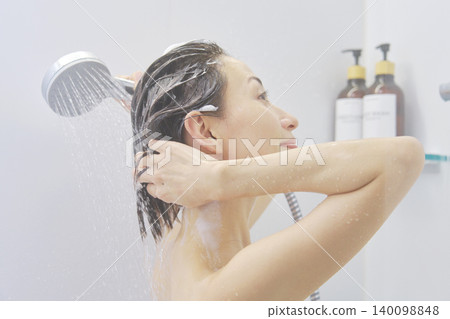 Woman rinsing her hair in the shower Woman rinsing her hair in the shower 140098848