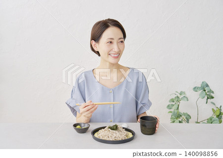 一位女士在客廳吃冷蕎麥麵 140098856