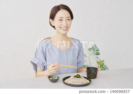 A woman eating cold soba noodles in the living room A woman eating cold soba noodles in the living room 140098857