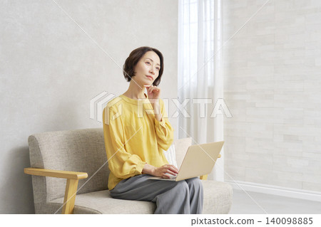 一位女士在客廳用電腦思考 140098885