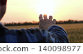 man hand close up stretched to sunset sky during countryside travel. silhouette of male hand at sunset in sunbeams, unity of traveler with nature in countryside 140098977