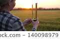 Agronomist with ruler in wheat field. Woman measures crop to check crop quality and crop readiness. Quality control supports modern crop production. Agronomist inspects wheat field 140098979