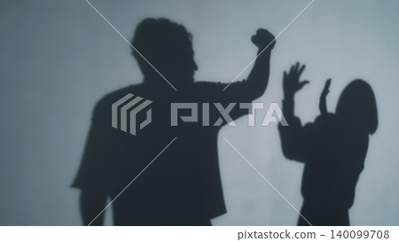 Silhouette of a man raising his fist at a woman Silhouette of a man raising his fist at a woman 140099708