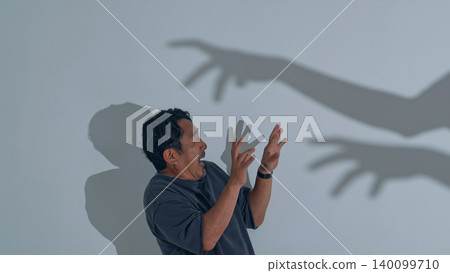 一個男人被怪物的影子嚇壞了。 一個男人被怪物的影子嚇壞了。 140099710