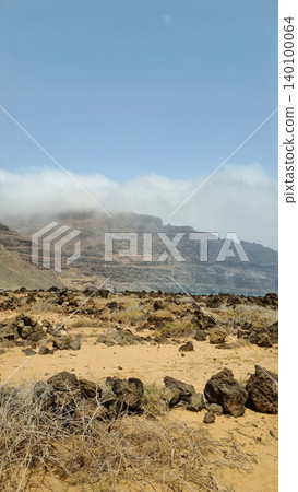 Wide view of Lanzarote desert landscape with volcanic hills and stark island beauty Wide view of Lanzarote desert landscape with volcanic hills and stark island beauty 140100064