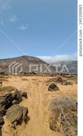 Wide view of Lanzarote desert landscape with volcanic hills and stark island beauty Wide view of Lanzarote desert landscape with volcanic hills and stark island beauty 140100065