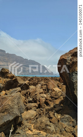Wide view of Lanzarote desert landscape with volcanic hills and stark island beauty Wide view of Lanzarote desert landscape with volcanic hills and stark island beauty 140100071