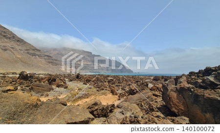 Wide view of Lanzarote desert landscape with volcanic hills and stark island beauty Wide view of Lanzarote desert landscape with volcanic hills and stark island beauty 140100072