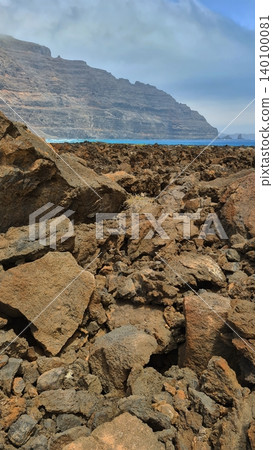 Wide view of Lanzarote desert landscape with volcanic hills and stark island beauty Wide view of Lanzarote desert landscape with volcanic hills and stark island beauty 140100081