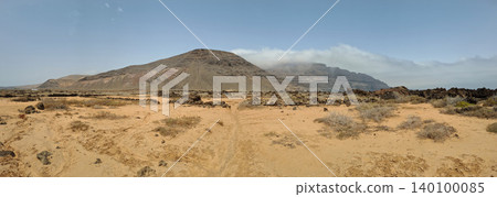 Wide view of Lanzarote desert landscape with volcanic hills and stark island beauty Wide view of Lanzarote desert landscape with volcanic hills and stark island beauty 140100085
