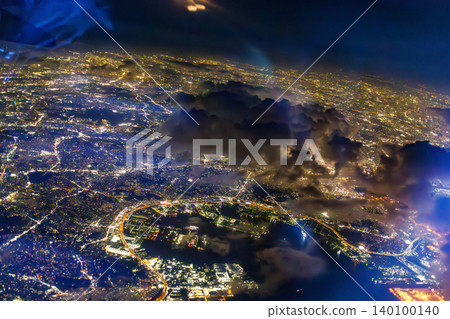 The window of a passenger plane flying from Haneda Airport to Naha. A view of Japan's nightscape from 10,000 meters above ground. Tokyo International Airport, Ota Ward, Tokyo. 140100140