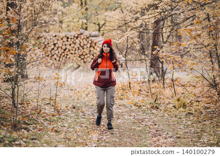 Woman walks along forest trail in DSCF0699 copy.jpg while looking up. Responsible autumn travel, eco-conscious outdoor lifestyle, authentic wilderness immersion. Woman walks along forest trail in DSCF0699 copy.jpg while looking up. Responsible autumn travel, eco-conscious outdoor lifestyle, authentic wilderness immersion. 140100279